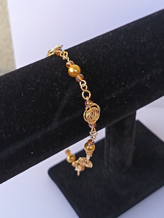 Pulsera nudo de rosa con perlas doradas