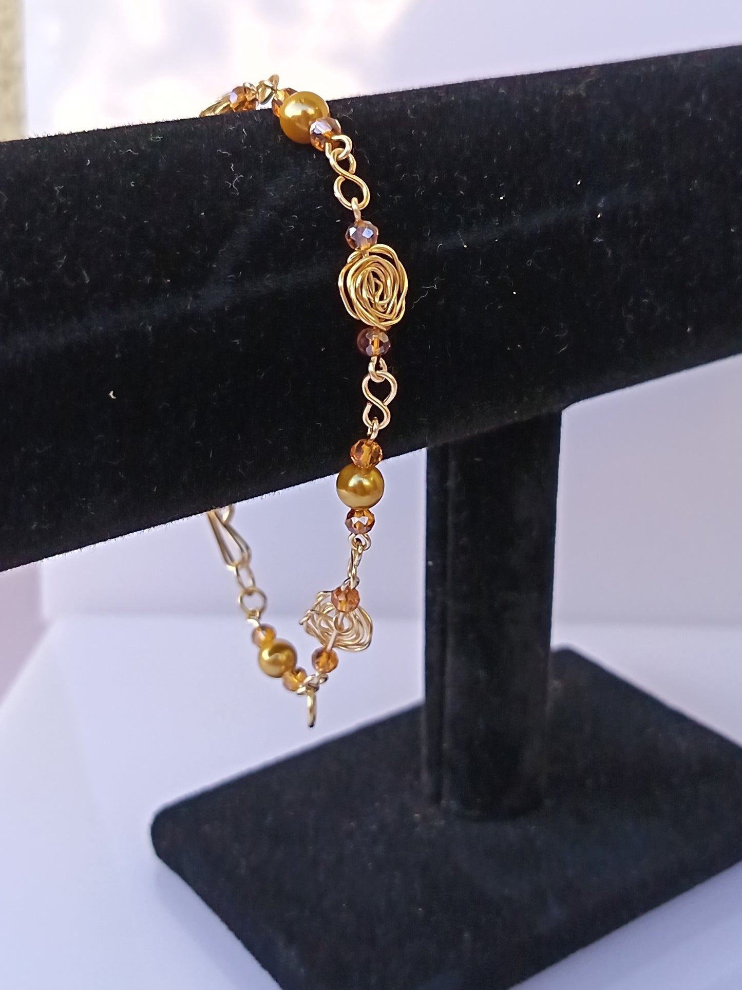Pulsera nudo de rosa con perlas doradas