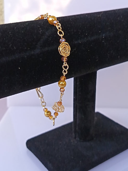 Pulsera nudo de rosa con perlas doradas