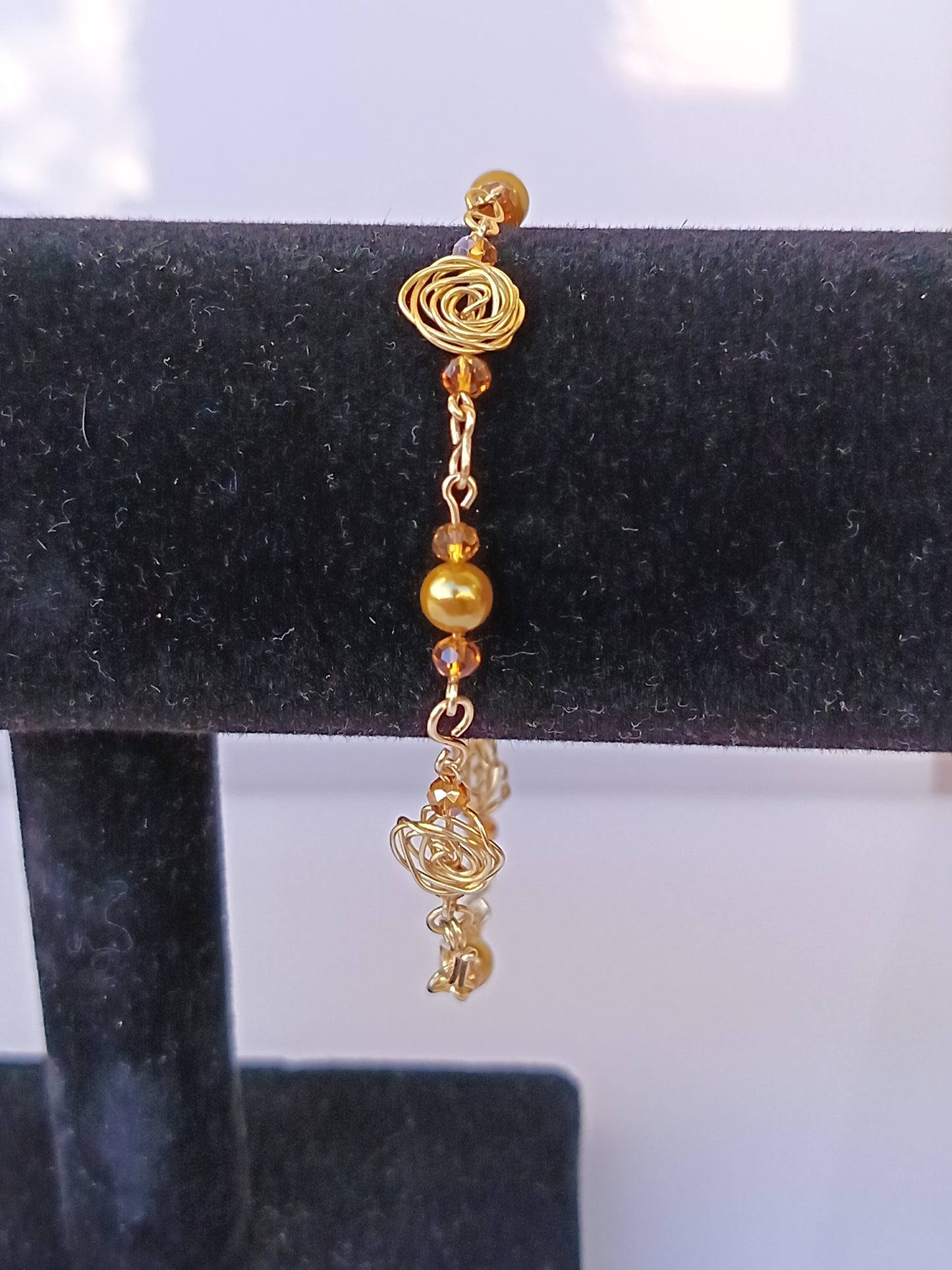 Pulsera nudo de rosa con perlas doradas